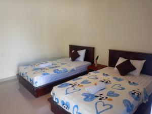 two beds sitting next to each other in a bedroom at HOME STAY ME'SARI tulamben in Tulamben