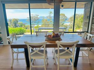 un tavolo in legno con sedie e un cesto di frutta. di The View @ Spring Beach a Spring Beach