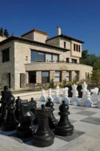 un tablero de ajedrez frente a una casa grande en Valeni Boutique Hotel & Spa en Portariá