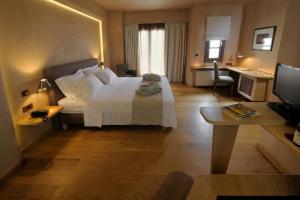 a bedroom with a large white bed and a desk at Valeni Boutique Hotel & Spa in Portaria