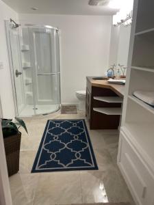 a bathroom with a shower and a blue rug at Welcome to Shibly's Retreat in Edmonton