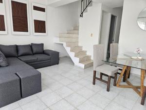 Una sala de estar con un sofá y una mesa de cristal. en Porto Vientos, en Cancún 12 fotos más