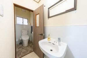 a bathroom with a sink and a toilet at SORA usjまで電車で8分 5つの寝室 貸切の宿で楽しい時間を過ごしてください in Osaka +39 photos