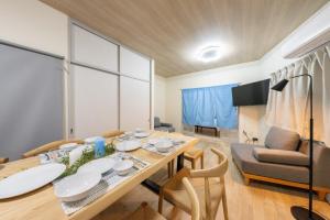 a dining room with a table and a couch at SORA usjまで電車で8分 5つの寝室 貸切の宿で楽しい時間を過ごしてください in Osaka