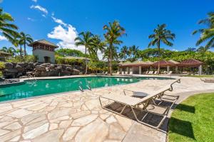 een zwembad met een tafel en stoelen in een resort bij 2001 Fairways at Mauna Lani in Waikoloa