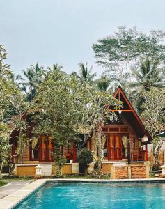 a house with a swimming pool in front of a house at D'karang Eco Lodge in Undisan