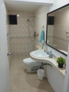 a bathroom with a sink and a toilet and a mirror at Green House in Cartagena de Indias