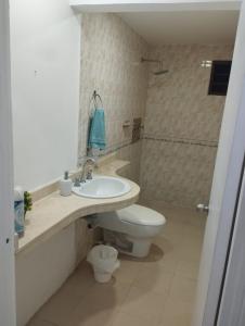 a bathroom with a white toilet and a sink at Green House in Cartagena de Indias