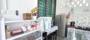 a room with a refrigerator and shelves with items at Homestay Villa H with POOL in Kuala Terengganu