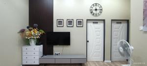 a living room with a tv on a wall at Homestay Villa H with POOL in Kuala Terengganu