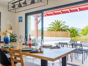 a dining room with a table with wine glasses at Cambo-les-Bains : Maison 3 Pièces, Piscine Privée, Internet, Parking - FR-1-495-148 in Cambo-les-Bains