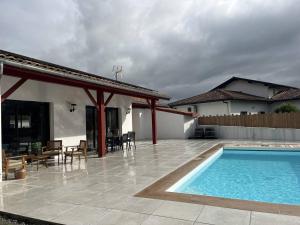 a patio with a swimming pool and a house at Cambo-les-Bains : Maison 3 Pièces, Piscine Privée, Internet, Parking - FR-1-495-148 in Cambo-les-Bains