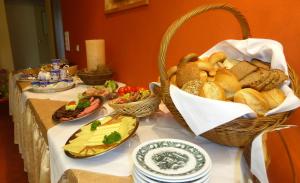 einen Tisch mit Körben mit Brot und anderen Lebensmitteln in der Unterkunft Hotel Haus Rameil in Lennestadt