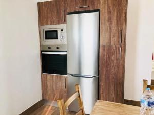 a stainless steel refrigerator in a kitchen with a microwave at Apartment Alegria in the stunning Village of Mozaga, Lanzarote in Mozaga
