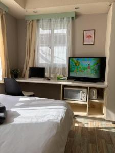 a bedroom with a bed and a flat screen tv at Shinjuku宿 in Tokyo