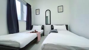 Dos camas una al lado de la otra en una habitación. en KLIA Mesahill Fully Air-Con Suite, Bandar Baru Nilai, 71800 Nilai, en Nilai