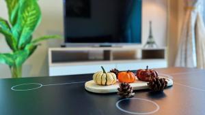 una mesa con calabazas y piñas en KLIA Mesahill Fully Air-Con Suite, Bandar Baru Nilai, 71800 Nilai, en Nilai