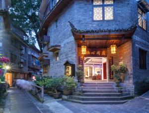 凤凰FenghuangQixin Guesthouse的前面有楼梯的石头建筑