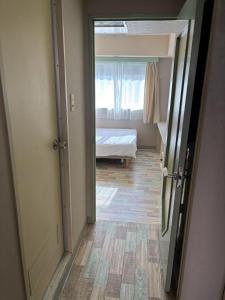a hallway with a bedroom with a bed and a window at Shinjuku宿 in Tokyo +13 photos