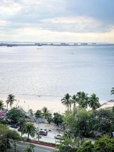 マニラにあるStunning & Luxury 4BR in Manila Bay White Beachのヤシの木と水のビーチの景色