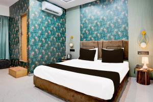 a bedroom with a large bed and a blue wall at Super Collection O Adajan Formerly Hotel Sky Palace in Surat