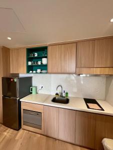 a kitchen with a sink and a black refrigerator at Aqua Blue Ocean View Condo - Free Swimming Pool in Hà My Tây (2) +31 photos