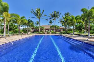 una piscina con palme e una casa di 2403 Kulalani a Waikoloa