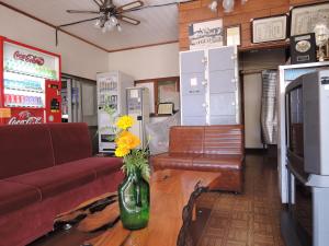 a living room with a couch and a vase with flowers on a table at Shintaku Sanso in Minamimaki