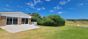 a house with a large yard with green grass at Pearly Bay in Pearly Beach