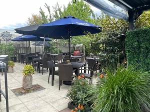 a patio with tables and chairs and an umbrella at Apartment 88 in Greytown