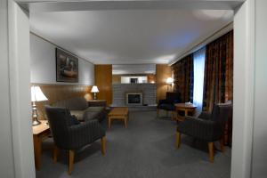 a living room with a couch and chairs and a fireplace at Motel Du Chevalier in Gatineau
