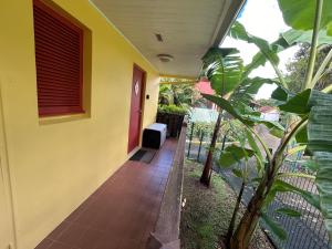 a hallway of a house with a red door at Studio palmiers royaux in Sainte-Anne