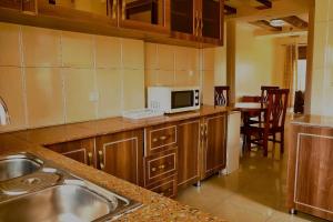 una cocina con fregadero y microondas en KIGALi LODGE APART, en Kigali