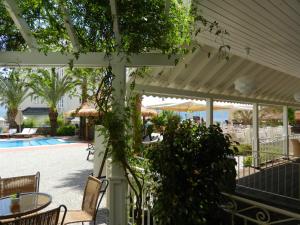 a white pergola with a table and chairs next to a pool at Hawaii Hotel in Marmaris