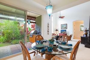 a dining room with a table and chairs and a living room at 206 Fairways at Mauna Lani in Waikoloa