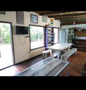 una habitación con mesas y bancos en un edificio en Hostel Finisterre, en La Pedrera