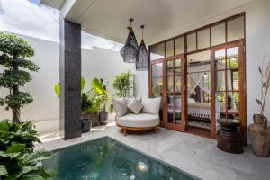 a villa with a swimming pool and a bedroom at Plawa Laguna Bali - Boutique Hotel & Suites in Canggu
