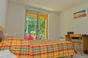 - une chambre avec un lit et une couverture tressée dans l'établissement VTF Le Domaine du Peyrichoux, à Singleyrac