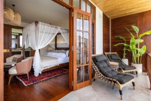 Schlafzimmer mit Himmelbett und Stühlen in der Unterkunft Plawa Laguna Bali in Canggu + 46 Fotos