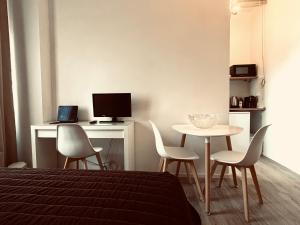 a bedroom with a table and chairs and a computer at Oriani39 B&B in Bologna
