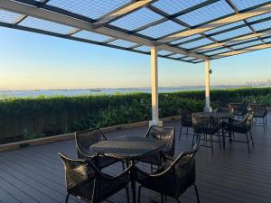 a patio with tables and chairs with a view of the ocean at Modern Luxury 5BR Sunset View beside Okada Manila in Manila