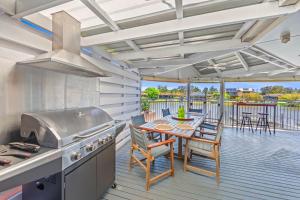 a kitchen with a grill and a table on a deck at Waterfront Paradise in Tweed Heads