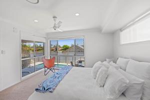 a white bedroom with a bed and a balcony at Waterfront Paradise in Tweed Heads +16 photos