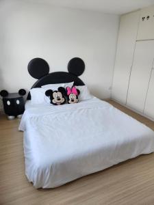 two dogs sitting on top of a white bed at Sunway Grid Mickey House 4-5pax, 8mins to Legoland in Iskandar Puteri