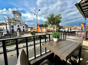 a wooden table on a balcony with a clock tower at San Roque Dpto in Cuenca
