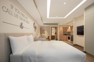 ein Schlafzimmer mit einem großen weißen Bett und ein Wohnzimmer in der Unterkunft Rove JBR in Dubai + 26 Fotos