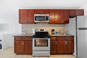 a kitchen with stainless steel appliances and wooden cabinets at Waikiki Ilikai Marina in Honolulu +31 photos