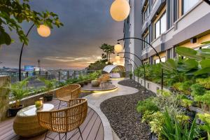a balcony with chairs and tables on a building at The Manohara Hotel Yogyakarta in Yogyakarta