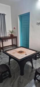 a wooden table in a room with a blue door at Blue Cove Villa Varkala in Varkala