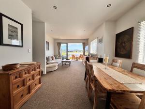 a large living room with a table and a couch at Charming Lakeview Golf Villa in Matarangi